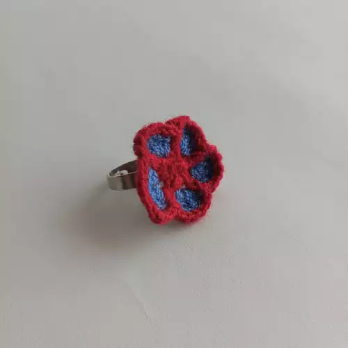 Anillo Flor tejido a crochet color azul con borde rojo