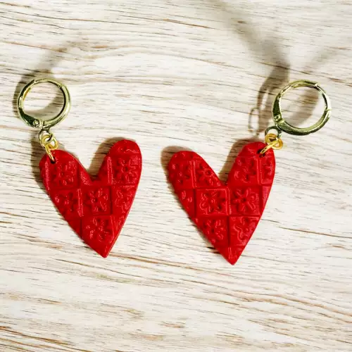Aretes corazones rojos con textura floral
