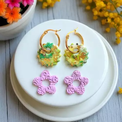 Aretes dorados con colgantes verdes y flores
