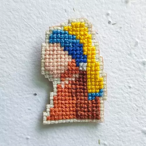 Pin bordado La joven de la perla punto de cruz 5x3cm