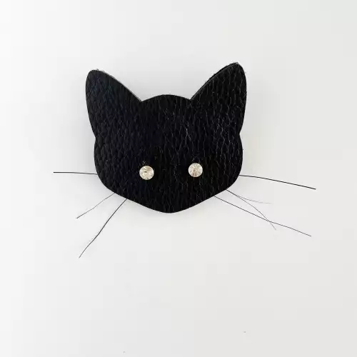 Prendedor gato en cuero negro con ojos brillantes